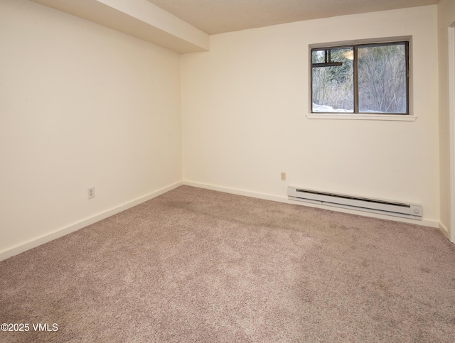 empty room with a baseboard heating unit, carpet floors, and baseboards