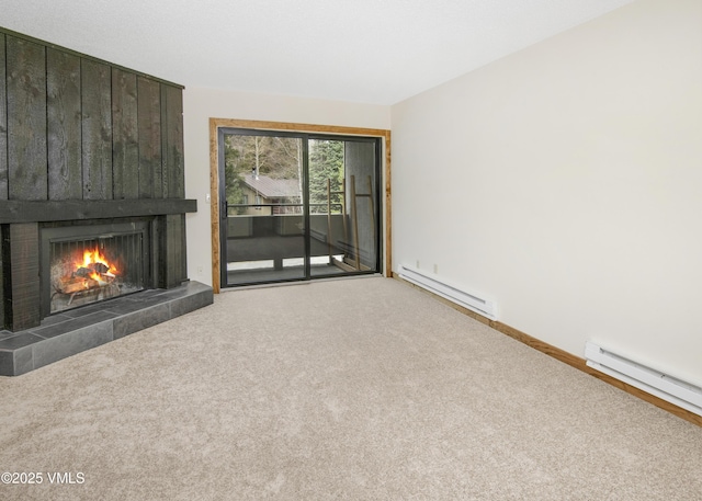 unfurnished living room with baseboard heating, baseboards, a tile fireplace, and carpet flooring