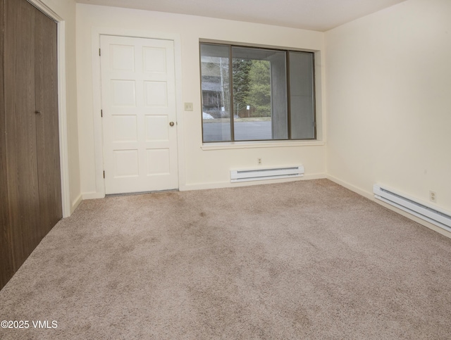 unfurnished room featuring baseboards, carpet flooring, and a baseboard radiator