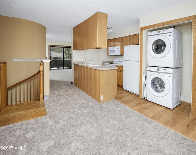 laundry room featuring light carpet, stacked washer / drying machine, light wood finished floors, and a sink