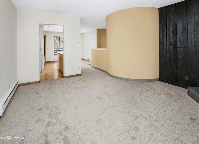 carpeted empty room with baseboard heating and baseboards