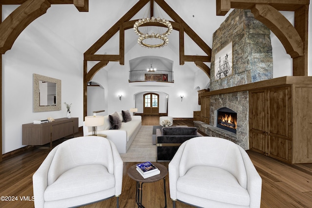 living room with high vaulted ceiling, a fireplace, wood finished floors, and an inviting chandelier