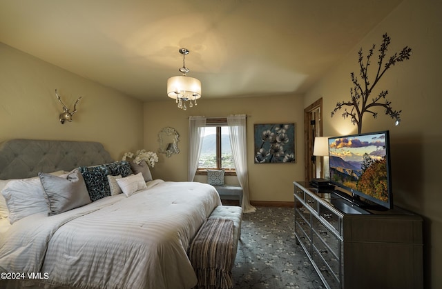 carpeted bedroom featuring a notable chandelier and baseboards