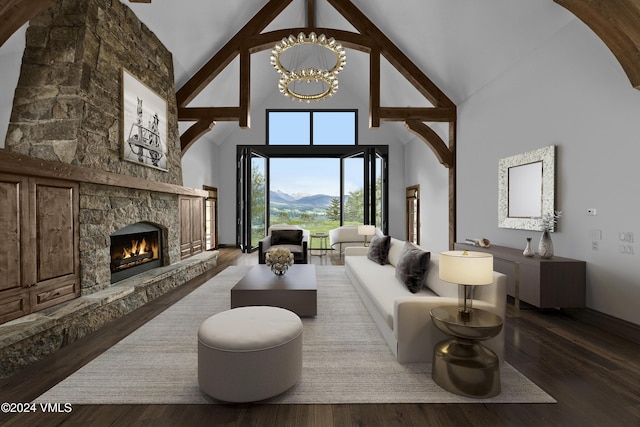 living room with high vaulted ceiling, a stone fireplace, wood finished floors, and an inviting chandelier