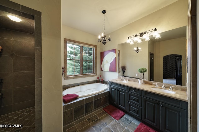 full bathroom featuring double vanity, a garden tub, vaulted ceiling, and a sink