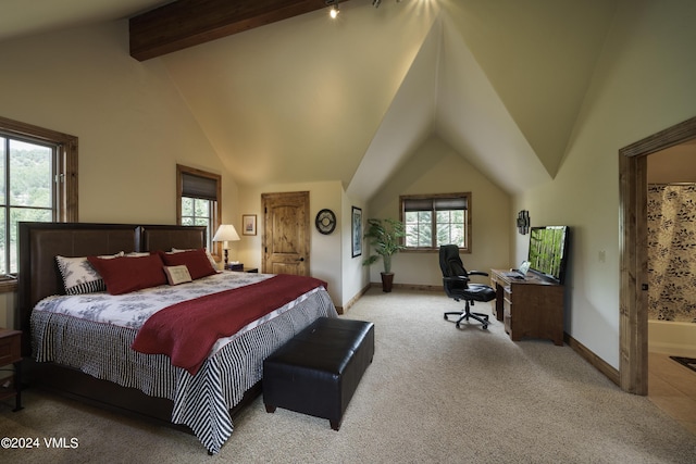 bedroom with light colored carpet, lofted ceiling with beams, and baseboards