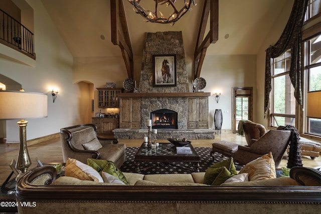 living area with high vaulted ceiling, a notable chandelier, a fireplace, and baseboards