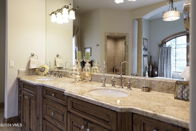 bathroom featuring double vanity, tile patterned flooring, a sink, and decorative columns