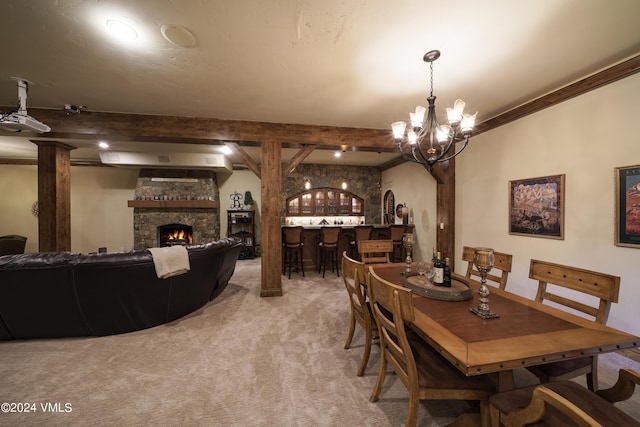 carpeted dining room with bar, a fireplace, ornamental molding, and beam ceiling