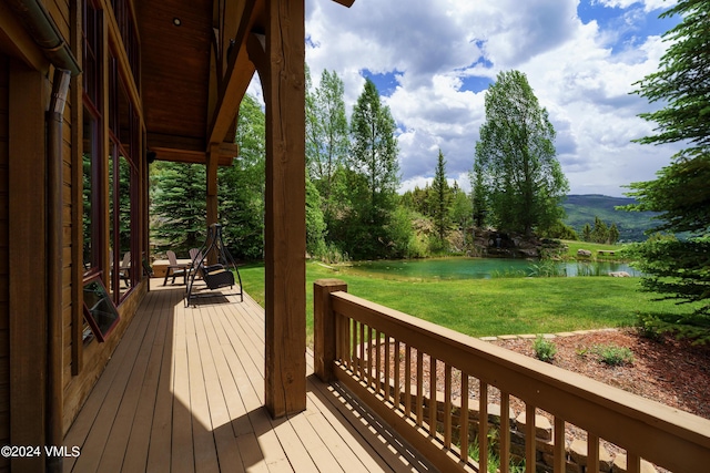 wooden terrace with a lawn and a water view