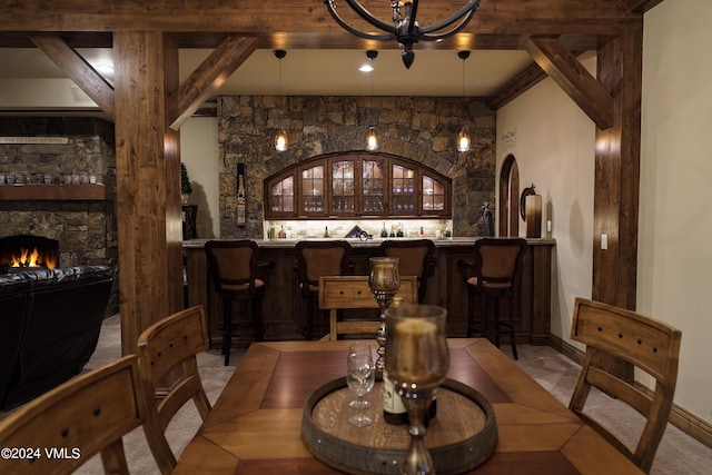 wine cellar featuring a fireplace, indoor bar, and beam ceiling