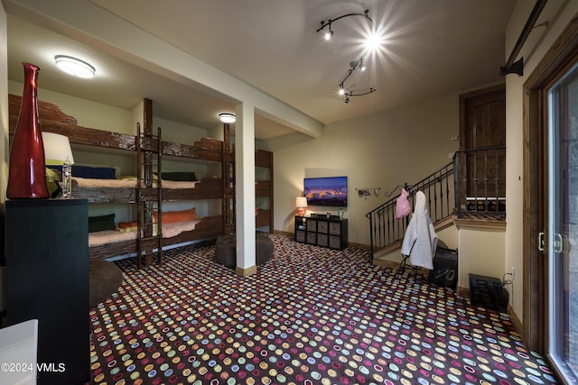 interior space with rail lighting, baseboards, and stairs