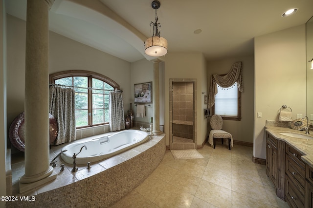 full bath featuring vanity, baseboards, a shower stall, a tub with jets, and ornate columns