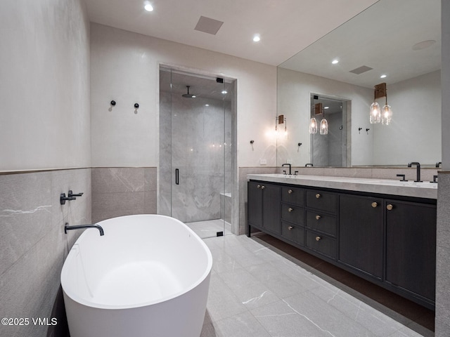 307 Rockledge Rd, Vail, CO 81657 - bathroom with a shower stall, double vanity, a freestanding bath, tile walls, and recessed lighting