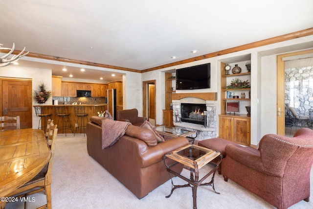 living room with built in features, a stone fireplace, and light carpet