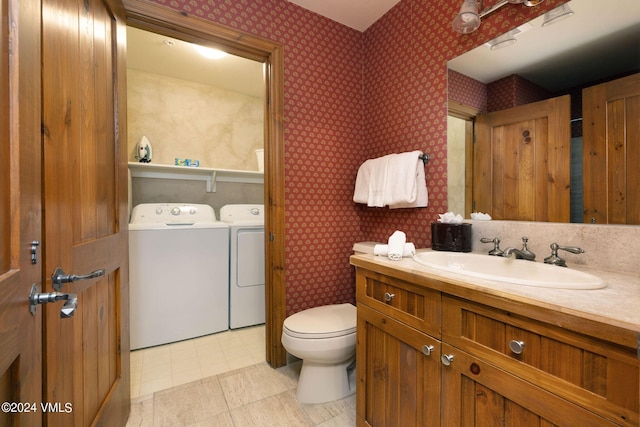 bathroom featuring vanity, washer and clothes dryer, and toilet