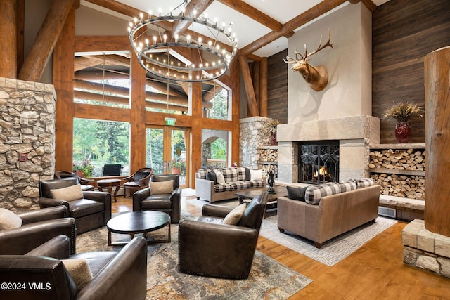 living room featuring hardwood / wood-style flooring, a premium fireplace, a high ceiling, and a notable chandelier