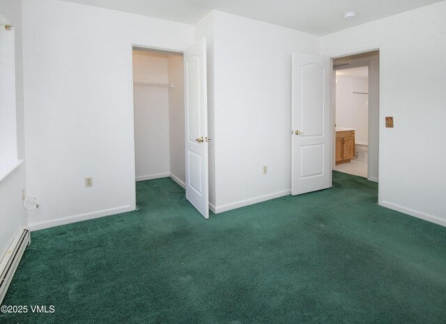 205 Crazy Horse Pt Unit 205, Edwards, CO 81632 - unfurnished bedroom featuring carpet, a baseboard radiator, a spacious closet, and a closet