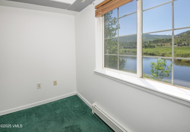205 Crazy Horse Pt Unit 205, Edwards, CO 81632 - empty room with dark colored carpet, a water and mountain view, and a baseboard radiator