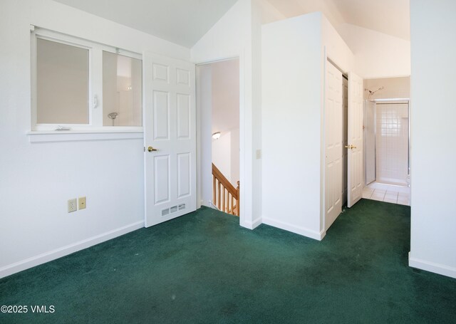205 Crazy Horse Pt Unit 205, Edwards, CO 81632 - unfurnished bedroom featuring vaulted ceiling, carpet, and connected bathroom