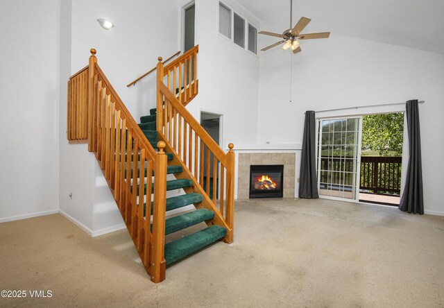 205 Crazy Horse Pt Unit 205, Edwards, CO 81632 - staircase featuring carpet flooring, ceiling fan, a tiled fireplace, and high vaulted ceiling