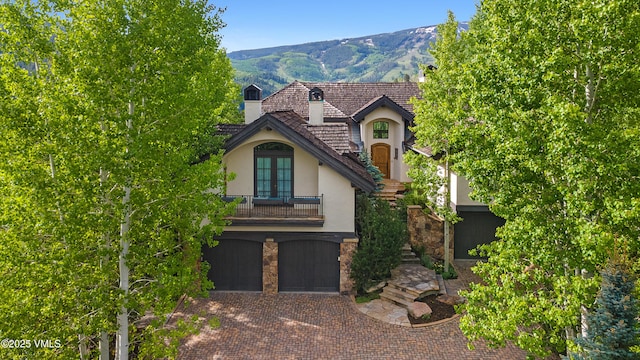 312 Holden Rd, Beaver Creek, CO 81620 - view of front of house featuring stucco siding, a balcony, a garage, decorative driveway, and a mountain view