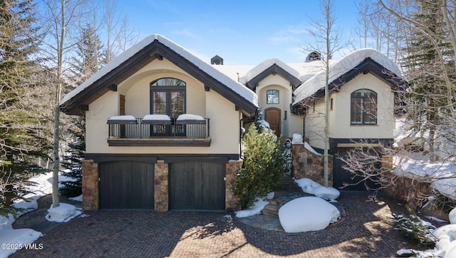 312 Holden Rd, Beaver Creek, CO 81620 - view of front of house featuring a balcony, french doors, a garage, stucco siding, and decorative driveway