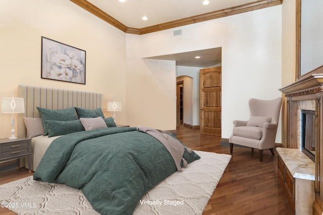 312 Holden Rd, Beaver Creek, CO 81620 - bedroom with arched walkways, crown molding, dark wood-style flooring, a glass covered fireplace, and recessed lighting
