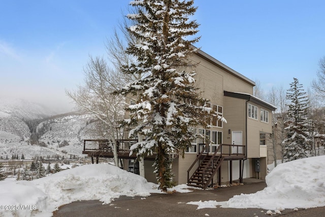 snow covered property featuring stairs