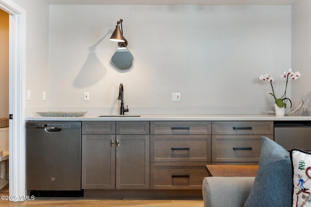 bar featuring a sink, light wood-style floors, and stainless steel dishwasher