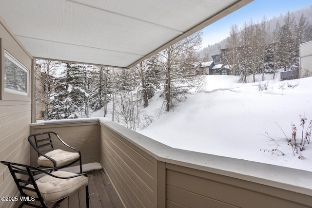 view of snow covered back of property