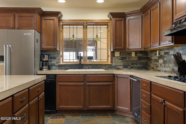 kitchen with under cabinet range hood, a sink, light countertops, and freestanding refrigerator