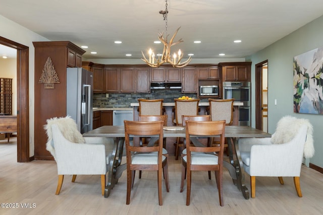 dining space featuring recessed lighting, light wood-style floors, and a chandelier