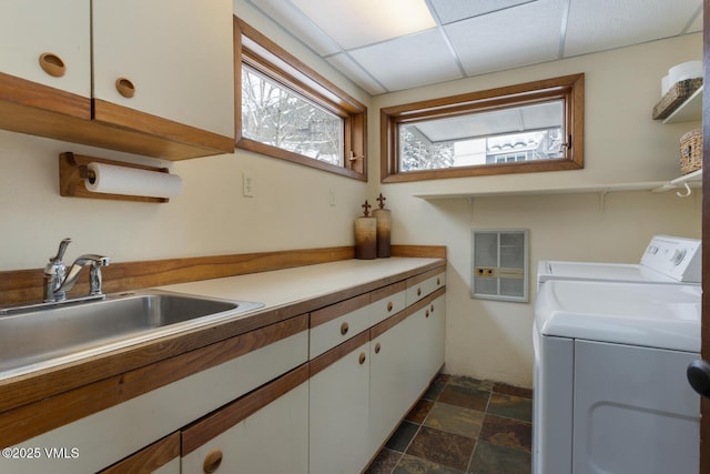 laundry room with a sink, cabinet space, washing machine and dryer, and stone finish floor