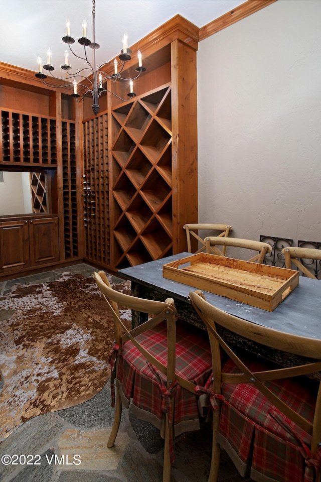 wine room with ornamental molding and an inviting chandelier