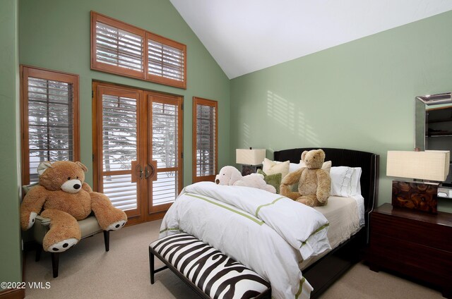 carpeted bedroom with multiple windows, access to outside, high vaulted ceiling, and french doors