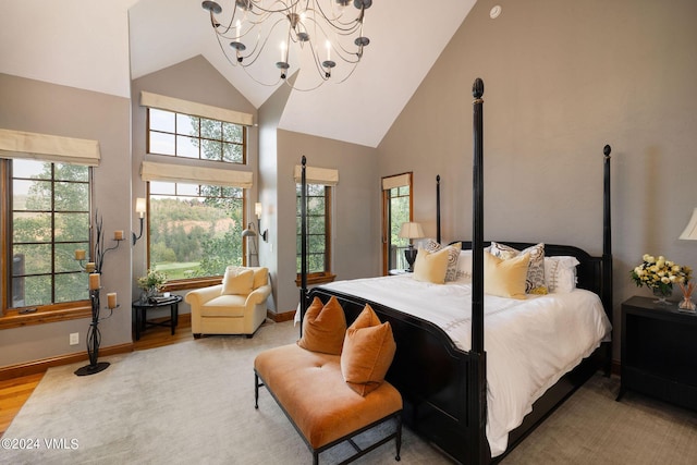 bedroom with a chandelier, high vaulted ceiling, and light hardwood / wood-style flooring