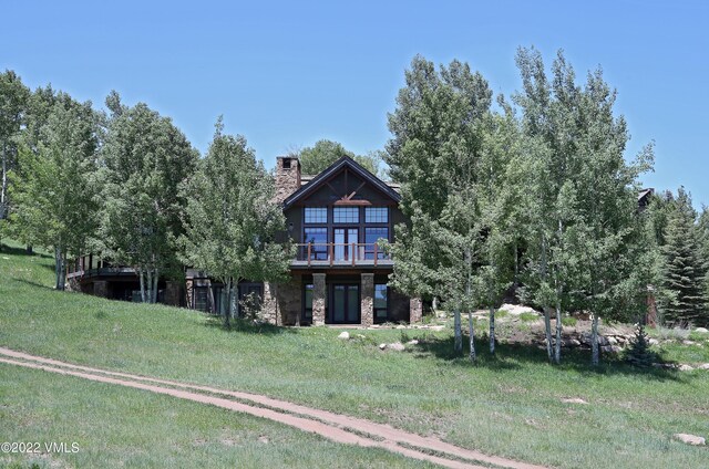 back of property featuring a wooden deck and a yard