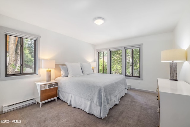 bedroom featuring multiple windows, carpet floors, and a baseboard heating unit