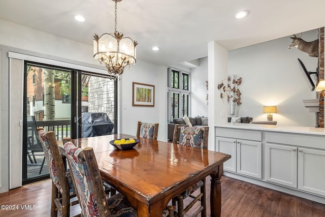 dining area with dark hardwood / wood-style flooring, a chandelier, and a healthy amount of sunlight