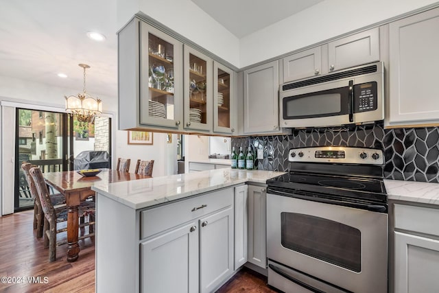 kitchen featuring hanging light fixtures, light stone countertops, appliances with stainless steel finishes, and gray cabinetry