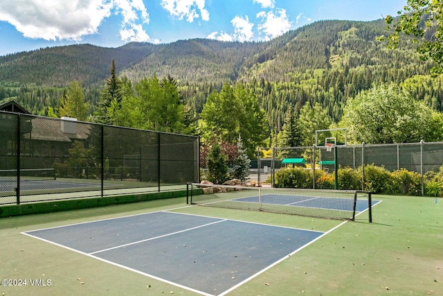 view of tennis court featuring a mountain view