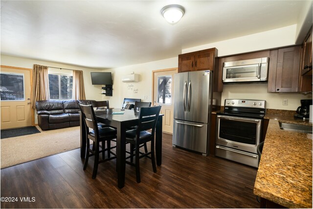 dining space with dark hardwood / wood-style floors, a wall mounted AC, and sink