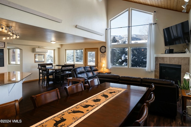 dining space featuring wood ceiling, dark wood-type flooring, a tile fireplace, high vaulted ceiling, and an AC wall unit