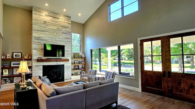146 Robins Egg Ln, Eagle, CO 81631 - living room with high vaulted ceiling, a stone fireplace, plenty of natural light, wood finished floors, and recessed lighting