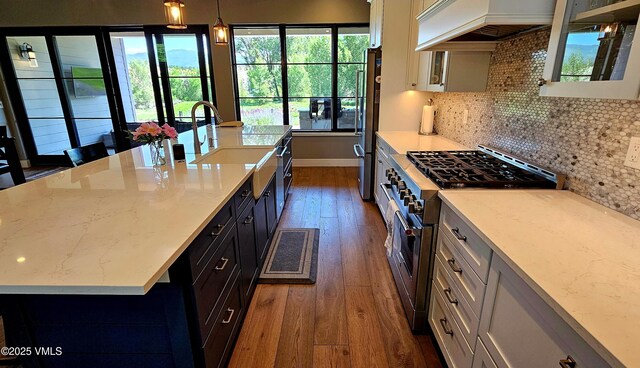 146 Robins Egg Ln, Eagle, CO 81631 - kitchen with stainless steel stove, dark wood finished floors, plenty of natural light, and custom range hood