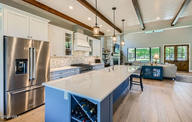 146 Robins Egg Ln, Eagle, CO 81631 - kitchen featuring premium range hood, high quality fridge, light countertops, backsplash, and an island with sink