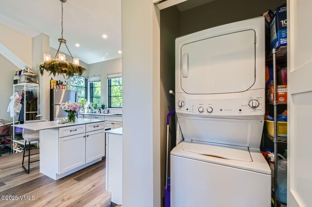 146 Robins Egg Ln, Eagle, CO 81631 - laundry room featuring stacked washer / drying machine, light wood finished floors, and recessed lighting