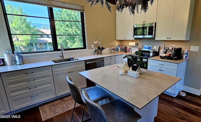 146 Robins Egg Ln, Eagle, CO 81631 - kitchen featuring appliances with stainless steel finishes, dark wood-style floors, a kitchen island, a kitchen breakfast bar, and white cabinets