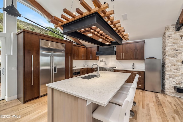 5780 Wildridge Rd E Unit A, Avon, CO 81620 - kitchen featuring built in fridge, a sink, freestanding refrigerator, light wood-type flooring, and backsplash